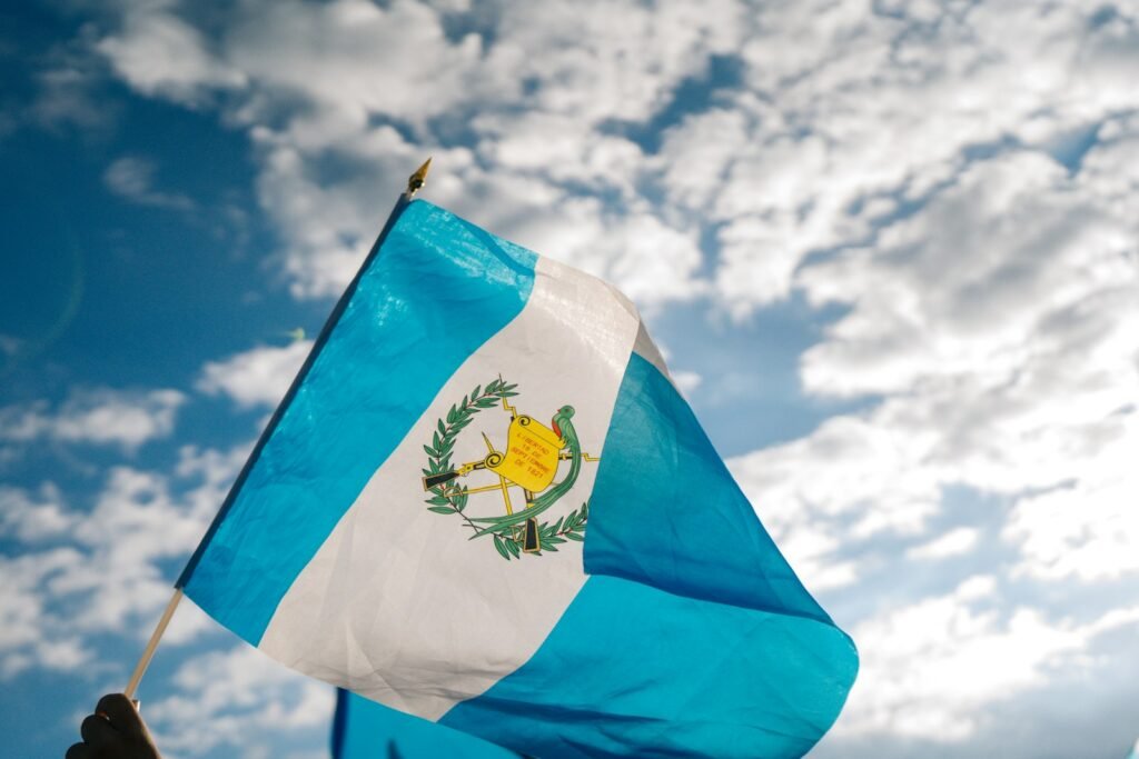 blue and white flag under blue and white sunny cloudy sky during daytime